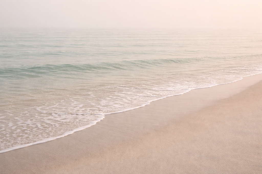 Calm beach shoreline in Victoria BC with gentle morning waves and soft natural light (grief counselling Victoria BC blog image)